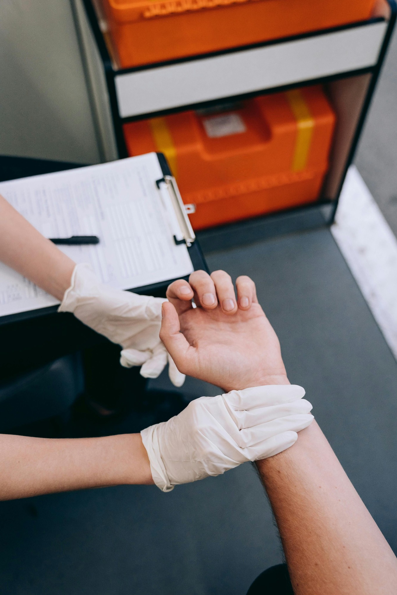 Clinical staff checking an applicant wrist while recording assessment information